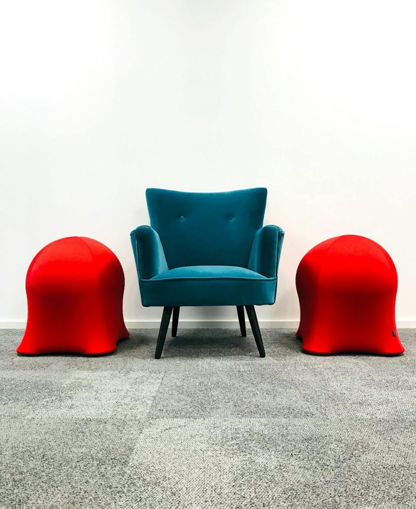 a blue armchair on the carpet